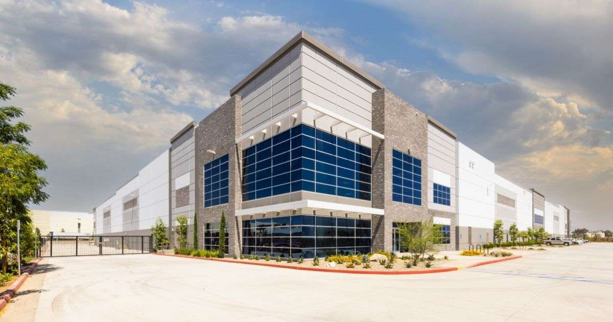 A new commercial development with landscaping, a large empty parking lot, and office and warehouse space for lease.