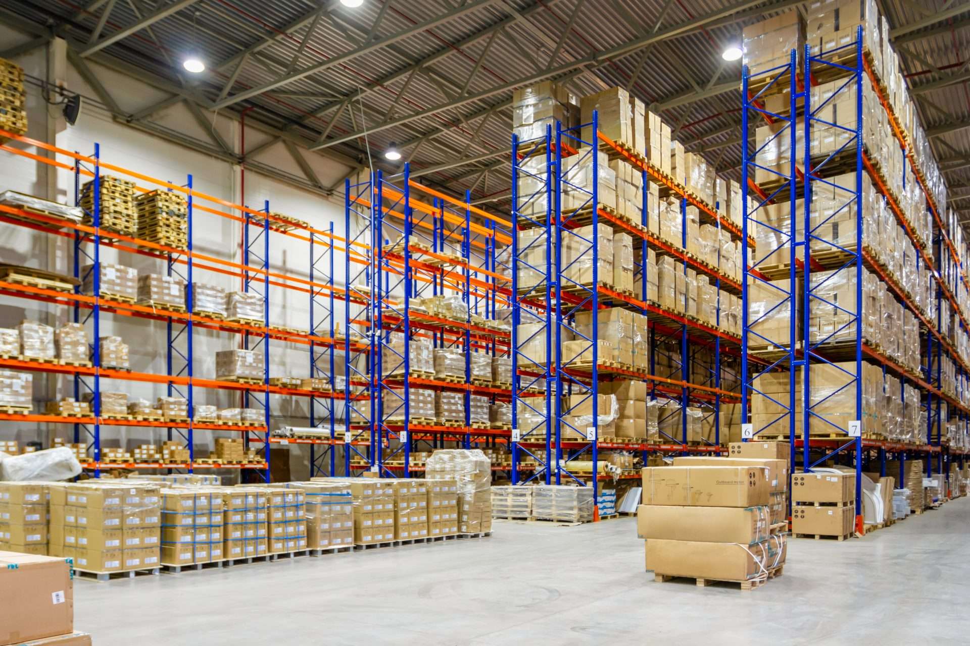 A warehouse with business inventory and boxes stacked on racks and pallets