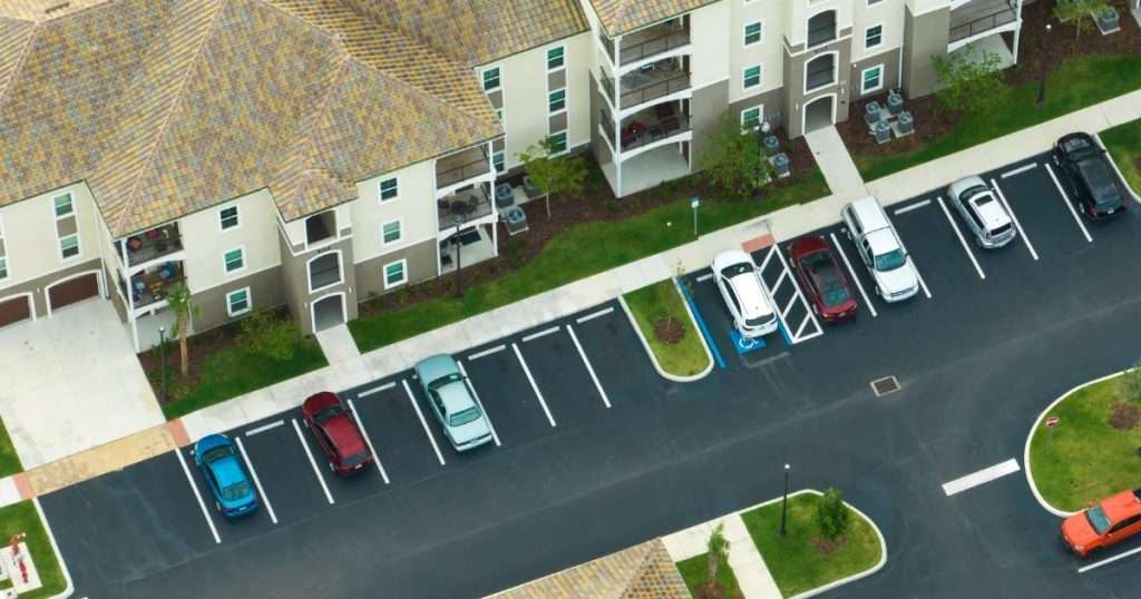 Aerial view of an apartment building and asphalt parking lot