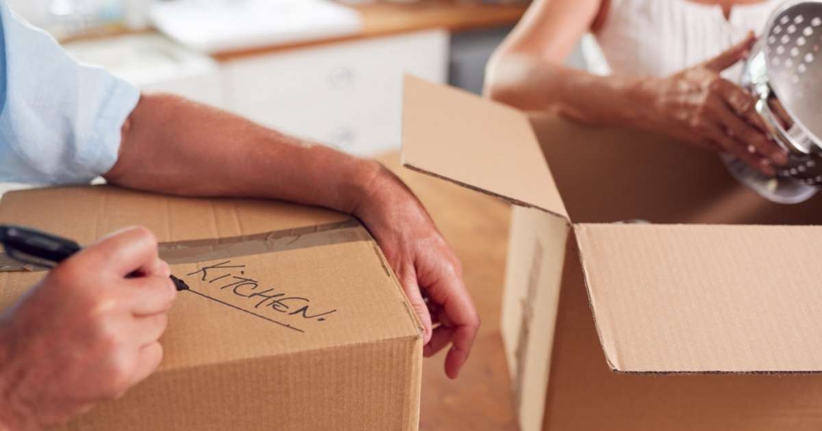 Two seniors placing items into boxes for a Greenville senior moving crew